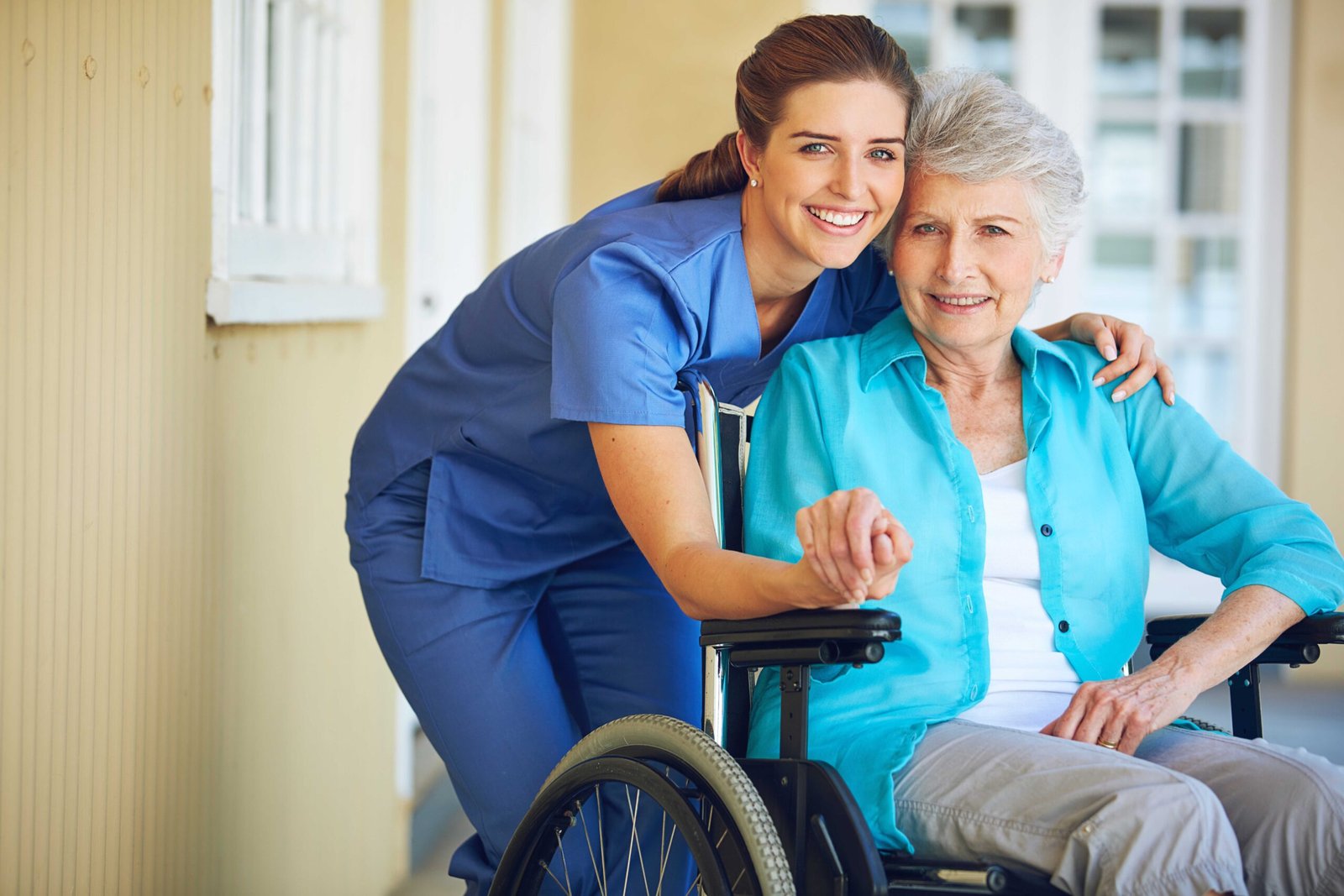 Portrait, caregiver or old woman in a wheelchair in hospital helping an elderly patient for support in clinic. Happy, medical or healthcare social worker talking to a senior person with a disability